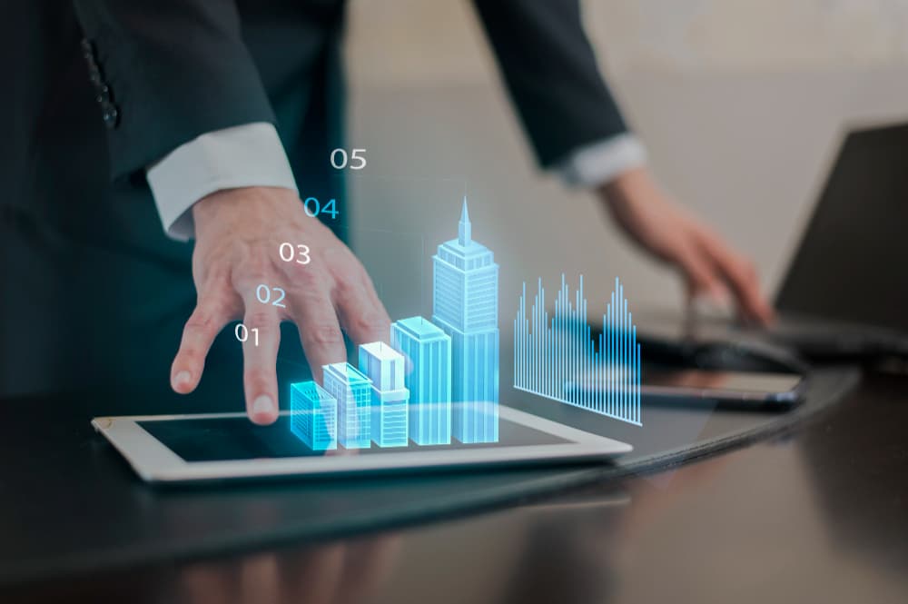 Person using a tablet with holographic augmentation of financial growth and buildings